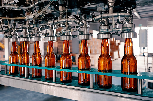 Beer bottles filling on the conveyor belt in the brewery factory Beer bottles filling on the conveyor belt in the brewery factory